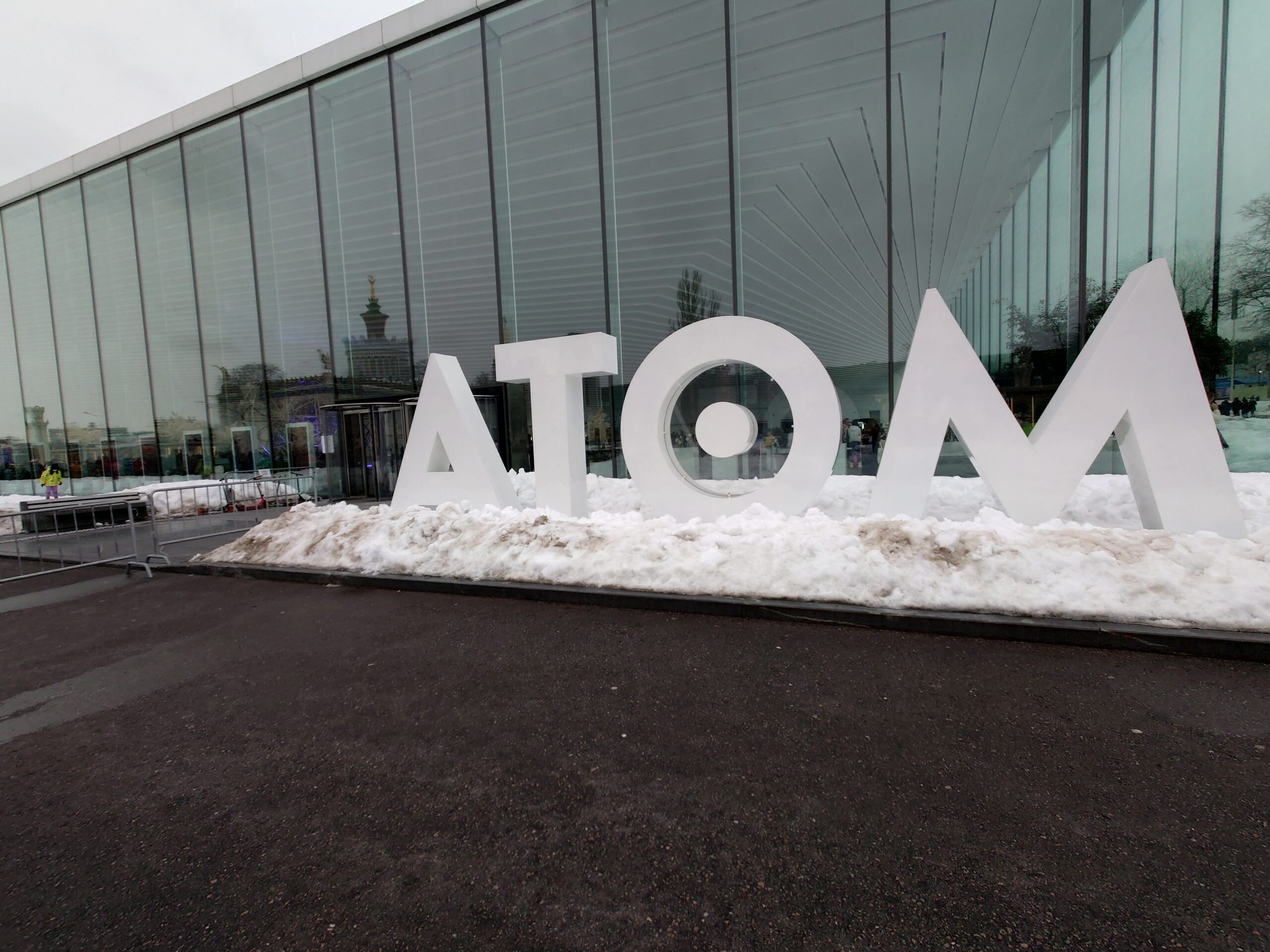 雪の中に立つ、ATOM博物館の大きなロゴ